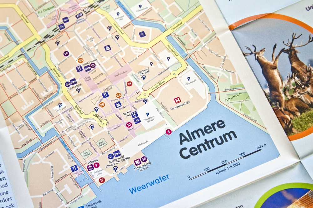 Op de achterzijde staat een gedetailleerde stadsplattegrond van Almere Centrum.